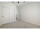 This bright bedroom offers a closet with sliding doors, ceiling fan, neutral carpet, and white trim at 1001 N Quail Ln, Gilbert, AZ 85233
