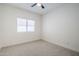 This bright bedroom has a window, ceiling fan, and neutral carpet. Recessed lighting and outlets are visible at 1001 N Quail Ln, Gilbert, AZ 85233