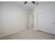 This bright bedroom offers a closet with sliding doors, ceiling fan, neutral carpet, and white trim at 1001 N Quail Ln, Gilbert, AZ 85233