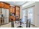 Bright kitchen with stainless steel refrigerator, warm wood cabinets, and a cozy breakfast nook near patio doors at 1001 N Quail Ln, Gilbert, AZ 85233