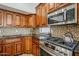 A stainless steel gas range and built in microwave highlight the custom cabinetry and granite countertops at 1001 N Quail Ln, Gilbert, AZ 85233