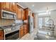 A modern kitchen features stainless steel appliances, mosaic backsplash, and granite countertops overlooking the backyard at 1001 N Quail Ln, Gilbert, AZ 85233