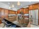 Gourmet kitchen featuring stainless steel appliances, custom wood cabinets, a breakfast bar, and granite countertops at 1001 N Quail Ln, Gilbert, AZ 85233