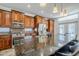Spacious kitchen boasts wood cabinetry, stainless steel appliances, mosaic backsplash, and a large granite island at 1001 N Quail Ln, Gilbert, AZ 85233