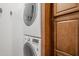 This laundry room includes a stacked washer/dryer with detailed control panel and a view of custom cabinetry at 1001 N Quail Ln, Gilbert, AZ 85233