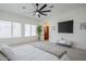 The main bedroom is bright and spacious with many windows, ceiling fan, recessed lights, and neutral carpet at 1001 N Quail Ln, Gilbert, AZ 85233
