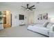The main bedroom is bright and spacious with many windows, an exit to the pool, ceiling fan, and neutral carpet at 1001 N Quail Ln, Gilbert, AZ 85233