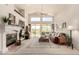 Bright living room with high ceilings, fireplace, and large windows overlooking the backyard at 10287 E Verbena Ln, Scottsdale, AZ 85255