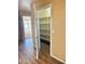 Hallway featuring wood look flooring, tan walls, and a partially open closet at 10528 W Jessie Ln, Peoria, AZ 85383