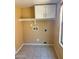 The laundry room features tile flooring, upper cabinets, and utility hookups for convenience at 10528 W Jessie Ln, Peoria, AZ 85383