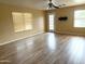 Inviting living room with wood floors, a ceiling fan, and a patio door at 10528 W Jessie Ln, Peoria, AZ 85383