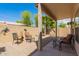 Covered back patio with gravel, brick wall, and seating, ideal for outdoor relaxation at 10652 W Coronado Rd, Avondale, AZ 85392