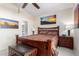Bedroom featuring a wooden bed frame, southwestern artwork, and a ceiling fan for comfortable living at 10652 W Coronado Rd, Avondale, AZ 85392