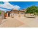 View of house with a two-car garage, desert landscaping, and tile roof with a blue sky and clouds in the background at 10652 W Coronado Rd, Avondale, AZ 85392