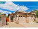 A well-kept two-car garage, desert landscaping, and tile roof under a bright blue and cloudy sky at 10652 W Coronado Rd, Avondale, AZ 85392