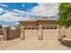 A well-maintained two-car garage with decorative windows and a stucco exterior under a bright, cloudy sky at 10652 W Coronado Rd, Avondale, AZ 85392