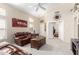 Bright living room with high ceilings, neutral colors, and comfortable leather furniture; bedroom visible through doorway at 10652 W Coronado Rd, Avondale, AZ 85392