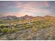 Scenic aerial view of luxury homes nestled in a desert landscape with majestic mountains in the background at sunset at 10811 E Acoma Dr, Scottsdale, AZ 85255