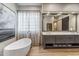 Bathroom featuring a bathtub with a large mirror, and a sliding barn door at 10811 E Acoma Dr, Scottsdale, AZ 85255