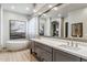 Modern bathroom featuring double sinks, bathtub, large mirror, and ample lighting at 10811 E Acoma Dr, Scottsdale, AZ 85255