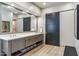 Bathroom featuring double sinks with gray cabinets, a large mirror, and barn door at 10811 E Acoma Dr, Scottsdale, AZ 85255