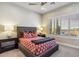 Cozy bedroom with a comfortable bed, stylish lamps, and plantation shutters overlooking desert views at 10811 E Acoma Dr, Scottsdale, AZ 85255