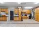 Spacious garage with ample storage cabinets, epoxy flooring, and organized shelving for tools and equipment at 10811 E Acoma Dr, Scottsdale, AZ 85255