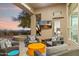 Covered patio featuring an outdoor living area with comfortable seating, a TV, and a view of the backyard, perfect for relaxation at 10811 E Acoma Dr, Scottsdale, AZ 85255
