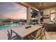 Covered patio featuring an outdoor dining area, comfortable seating, and a view of the pool, perfect for enjoying the outdoors at 10811 E Acoma Dr, Scottsdale, AZ 85255