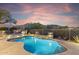 Backyard pool features a rock waterfall feature, built in fire pit, and desert views at 10811 E Acoma Dr, Scottsdale, AZ 85255