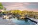 Beautiful pool with waterfall feature, desert landscaping, and comfortable lounge chairs, perfect for relaxation and entertainment at 10811 E Acoma Dr, Scottsdale, AZ 85255