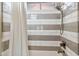Shower featuring white and grey horizontally laid tile and a shower curtain at 10811 E Acoma Dr, Scottsdale, AZ 85255