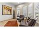 Sitting area with tile floors, shutters, leather chairs, and wall art at 10811 E Acoma Dr, Scottsdale, AZ 85255