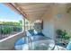 Relax on this covered patio with a glass table and view of the backyard and surrounding greenery at 1120 N Val Vista Dr # 10, Gilbert, AZ 85234