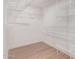 Spacious walk-in closet featuring white wire shelving and light wood-look flooring at 113 S Ocean Dr, Gilbert, AZ 85233