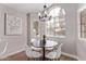 Bright dining area with circular table, white chairs, arched window, and elegant chandelier at 113 S Ocean Dr, Gilbert, AZ 85233