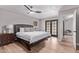 Large primary bedroom with hardwood flooring, door to private patio, and overhead fan at 113 S Ocean Dr, Gilbert, AZ 85233