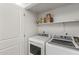 Functional laundry room featuring a washer, dryer, and built-in shelving for storage at 11333 N 92Nd St # 2049, Scottsdale, AZ 85260