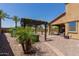 Captivating backyard featuring a pergola-covered seating area, lush palm trees, and desert landscaping for relaxation at 11466 N 162Nd Ln, Surprise, AZ 85379
