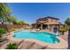 Stunning backyard oasis with a large pool, swim-up bar, and ample lounge space surrounded by desert landscaping at 11466 N 162Nd Ln, Surprise, AZ 85379