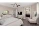 Large primary bedroom is appointed with custom dressers, a ceiling fan, and nearby bathroom at 11466 N 162Nd Ln, Surprise, AZ 85379