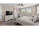 Comfortable primary bedroom features a ceiling fan, dresser, and mirror with easy access to the ensuite bathroom at 11466 N 162Nd Ln, Surprise, AZ 85379
