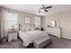 Relaxing primary bedroom with a ceiling fan, large windows, and custom decor at 11466 N 162Nd Ln, Surprise, AZ 85379