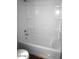 Bright white bathroom features tub with shower and built-in shelves for storage at 12245 N 21St Ave # 1, Phoenix, AZ 85029
