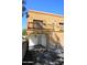 Tan two-story home with balcony and covered parking area, nestled beneath a clear blue sky at 12245 N 21St Ave # 1, Phoenix, AZ 85029