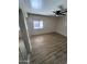 Spacious bedroom with wood-look flooring, a ceiling fan, and large windows at 12422 N 121St Dr, El Mirage, AZ 85335
