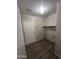 Functional laundry room with tile flooring, shelving, and utility connections for washer and dryer at 12422 N 121St Dr, El Mirage, AZ 85335