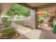 Relaxing covered patio featuring a grill and an outdoor dining area with lush landscaping views at 12714 W Copperstone Dr, Sun City West, AZ 85375