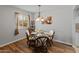 Dining area with a glass table, stylish chairs, a modern chandelier, and hardwood flooring at 12714 W Copperstone Dr, Sun City West, AZ 85375