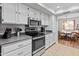 Modern kitchen with stainless steel appliances and white cabinets at 12714 W Copperstone Dr, Sun City West, AZ 85375